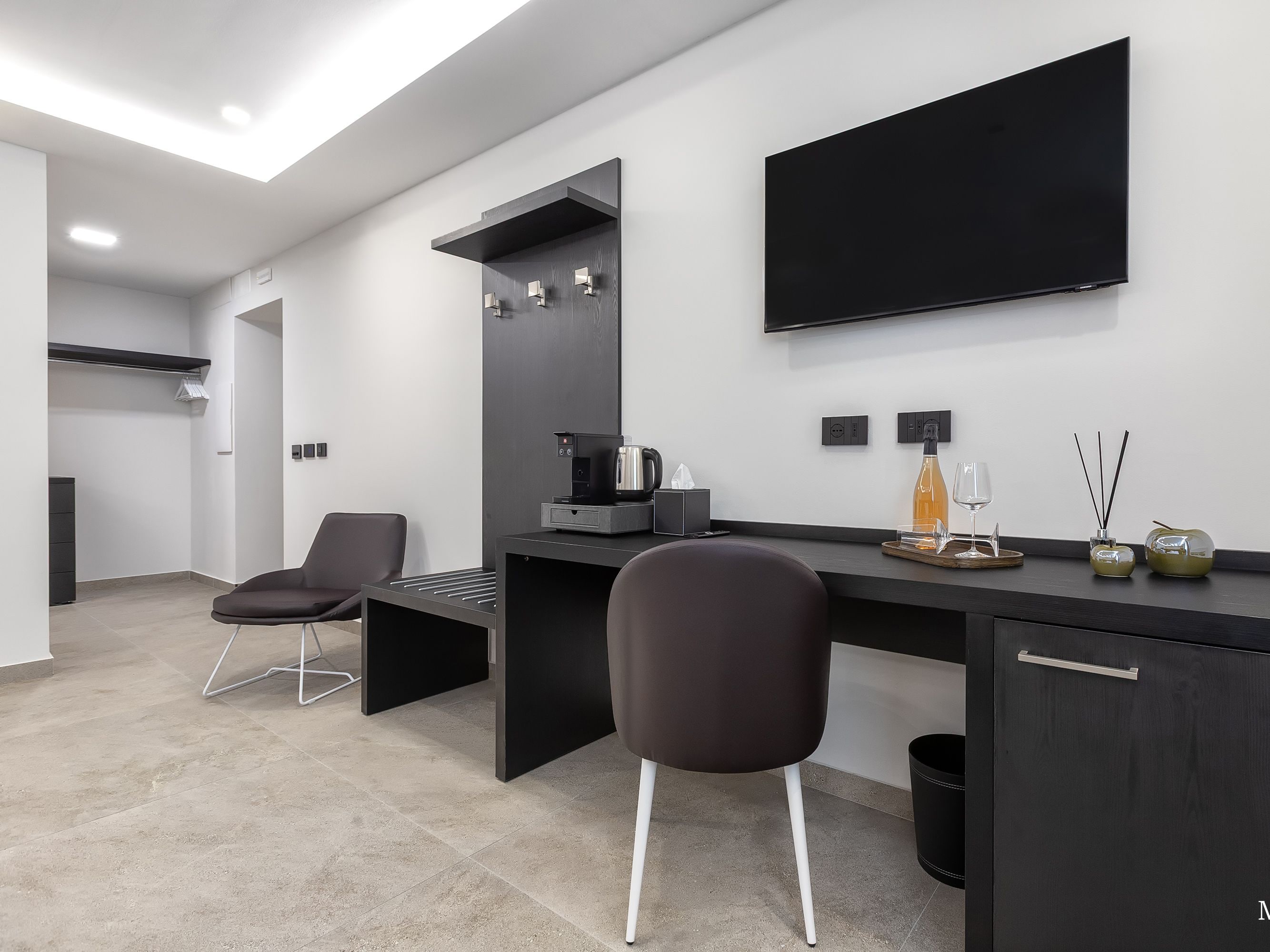 Una cocina moderna con encimera negra, estufa integrada y televisor de pantalla plana montado en la pared.