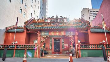 A traditional Chinese building with ornate architecture, including a red entrance and green roof tiles.