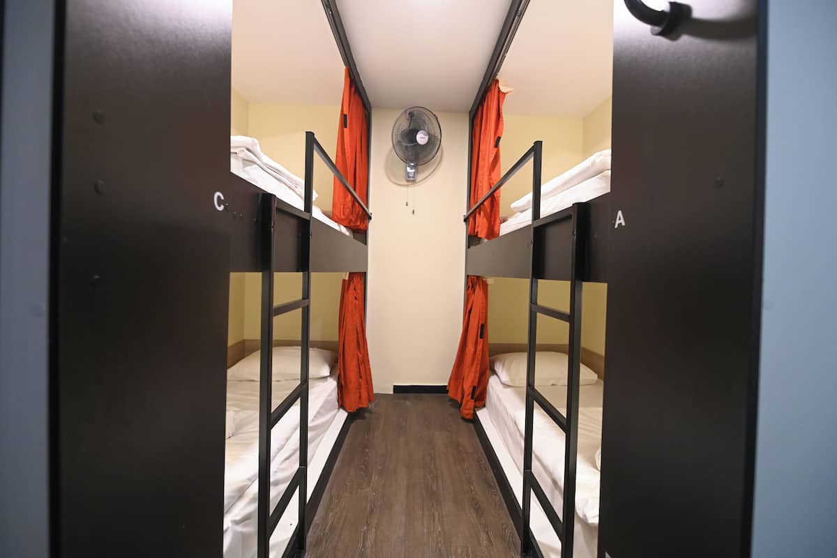 A room with bunk beds, a ceiling fan, and a door labeled 'C' and 'A'.