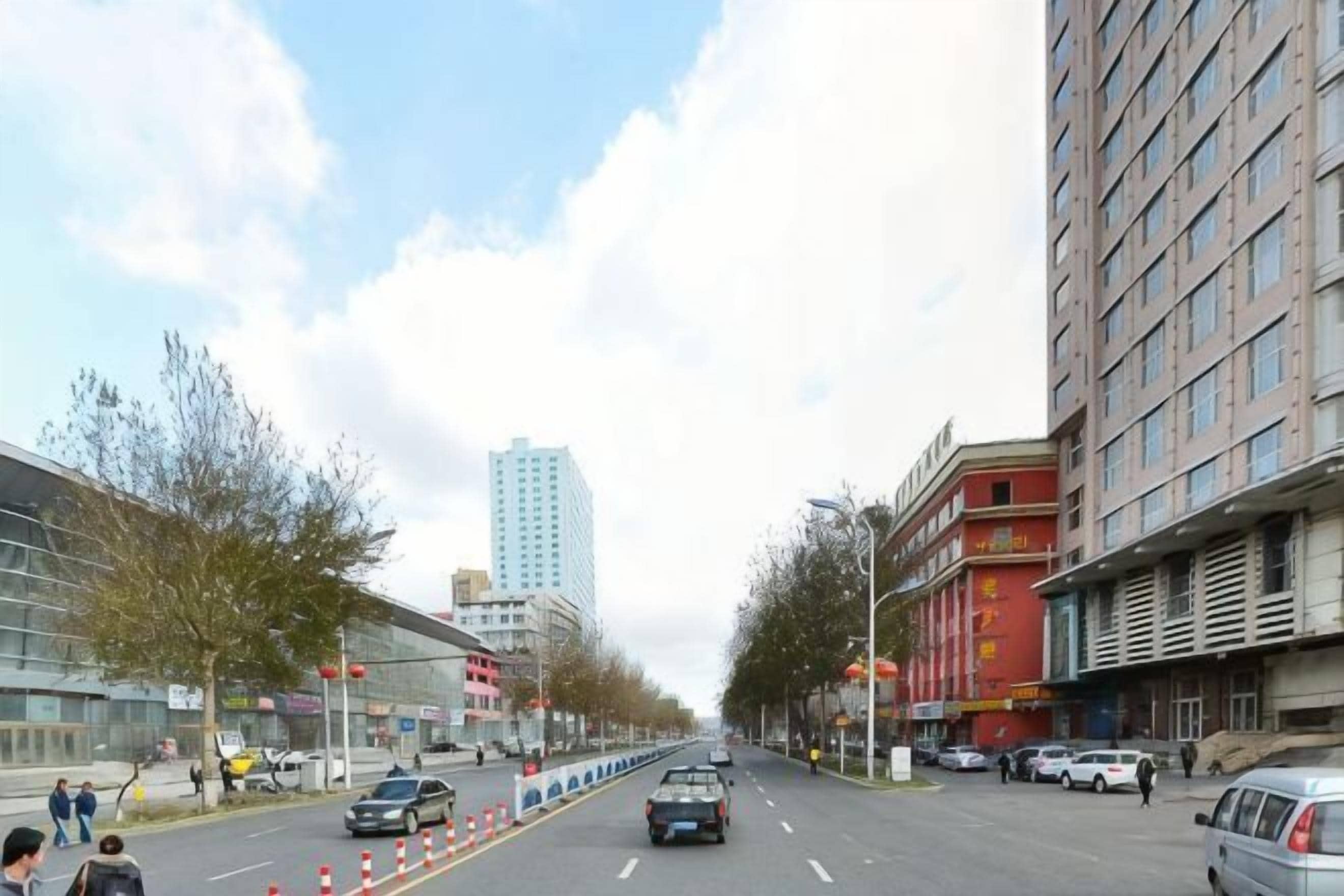 A city street with buildings, cars, and pedestrians.