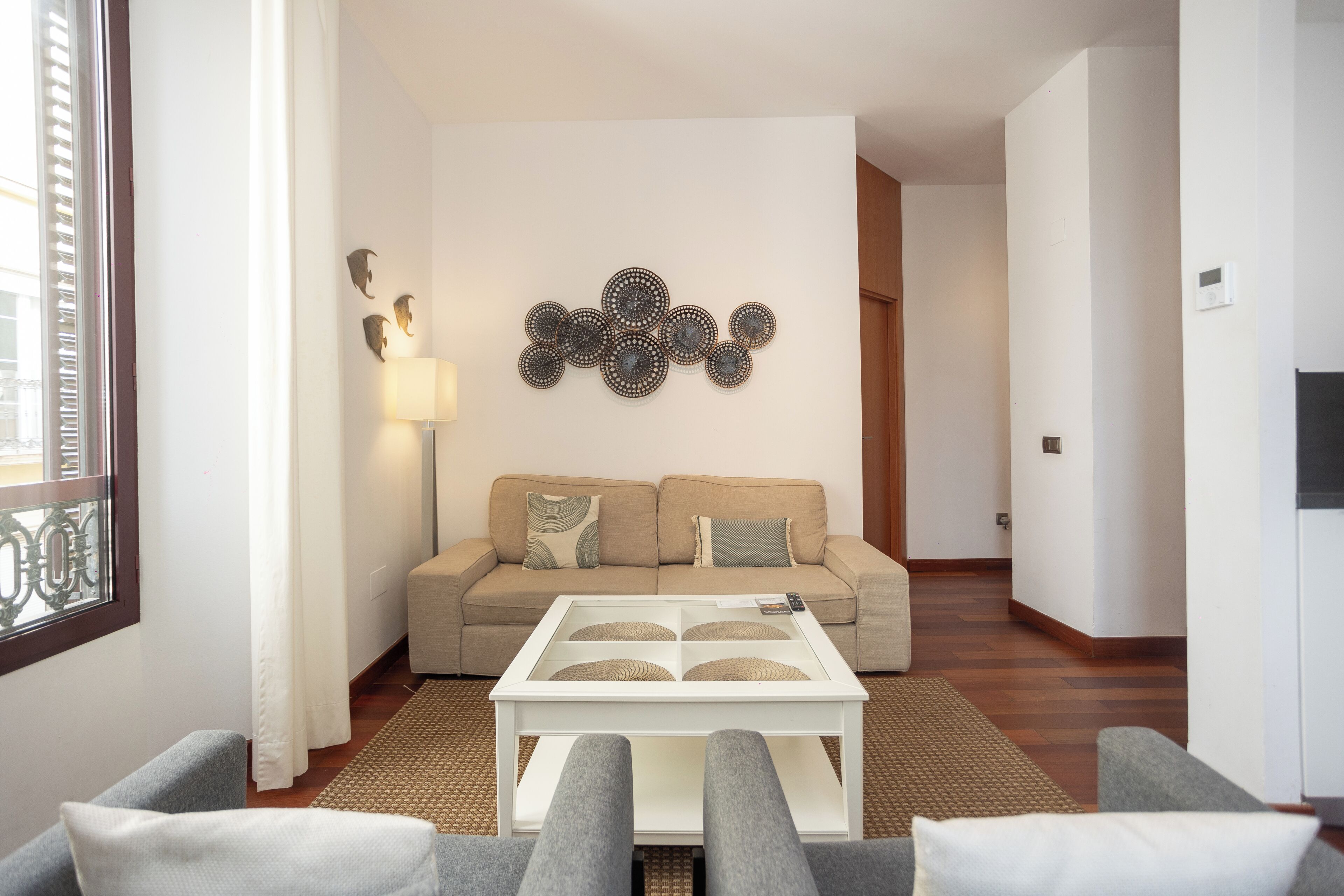 Una sala de estar moderna con un sofá, una mesa de centro y arte decorativo en la pared.