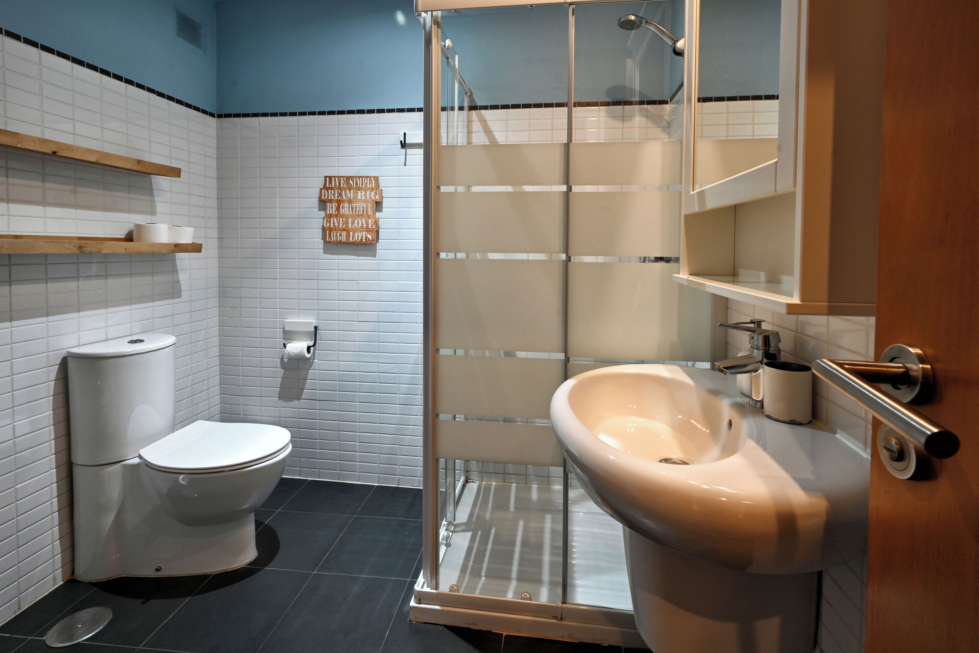 Une salle de bain avec des toilettes, un lavabo et une douche.