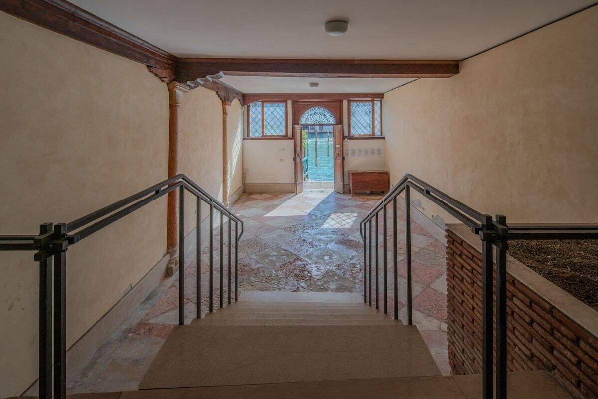 Un escalier avec une rampe menant à une porte dotée d’une fenêtre.