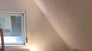 A small, cozy room with two beds, a ladder, a lamp, and a radiator. - Apartment 'Peter 2' with Private Terrace and Wi-Fi (Hessen - Michelstadt)