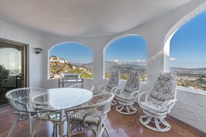 A terrace with a glass table and wicker chairs, overlooking a mountainous landscape. - Villa 'Celeste' with Sea View, Wi-Fi and Air Conditioning (Salobreña (Granada))