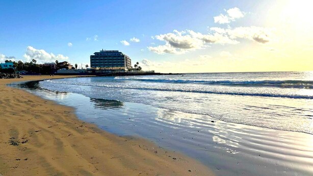 A beach with a building in the background.