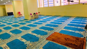 A spacious room with a patterned carpet, chairs, and a large window. - vivyan al Gemmayzeh  (Makkah)