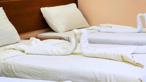 Two neatly made beds with white linens and pillows, arranged in a hotel room. - vivyan al Gemmayzeh  (Makkah)