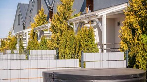 A residential area with modern houses, a wooden deck, and a fenced yard.