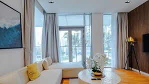 Leilighet – deluxe, balkong, bakgårdsutsikt | Oppholdsområde | En 55-tommers smart-TV med digitale kanaler