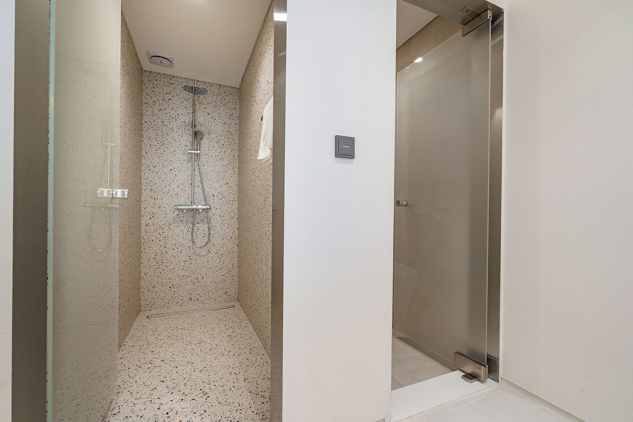 Ein modernes Badezimmer mit Dusche, Toilette und einer Duschkabine.