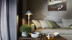 A cozy living room with a sofa, a small table with a lamp, a potted plant, and a tea set. - Luxury Design Apartment Downtown - FREE PARKING (Milano)