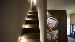A modern staircase with integrated lighting, leading to a room with a large circular window and a view of a cityscape. - Luxury Design Apartment Downtown - FREE PARKING (Milano)