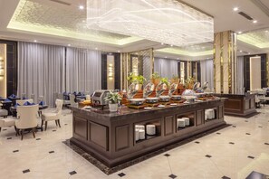 A hotel lobby with a buffet area, seating arrangements, and a decorative ceiling. - Meliá Vinpearl Hai Phong Rivera (Hai Phong)