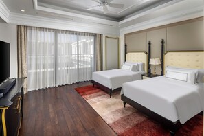 A hotel room with two beds, a TV, a ceiling fan, and a large window with curtains. - MeliĆ” Vinpearl Hai Phong Rivera (Hai Phong)
