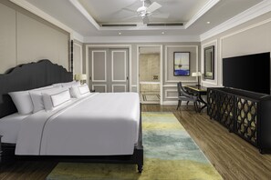 A hotel room with a large bed, a desk, a television, and a ceiling fan. - Meliá Vinpearl Hai Phong Rivera (Hai Phong)