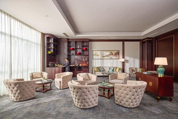 A hotel lobby with a seating area, a reception desk, and a large window with curtains. - MeliĆ” Vinpearl Hai Phong Rivera (Hai Phong Municipality)