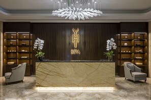 A reception desk with a marble top, a chandelier, and shelves with decorative items. - MeliĆ” Vinpearl Hai Phong Rivera (Hai Phong Municipality)