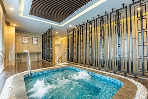 A spa area with a hot tub, tiled flooring, and a wall with decorative panels. - MeliĆ” Vinpearl Hai Phong Rivera (Hai Phong Municipality)