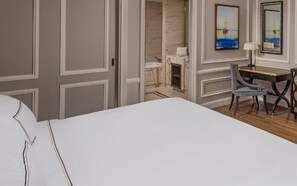A hotel room with a bed, a desk, a chair, and two paintings on the wall. - MeliĆ” Vinpearl Hai Phong Rivera (Hai Phong Municipality)