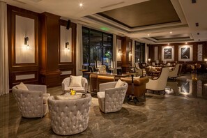A spacious lobby with plush seating, large windows, and modern lighting fixtures. - MeliĆ” Vinpearl Hai Phong Rivera (Hai Phong Municipality)