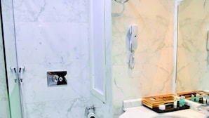 A bathroom with a toilet, a sink, a mirror, and a shower. - AlFajr AlBadie Hotel 1 (Makkah)