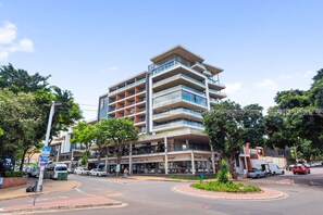 A multi-story hotel with balconies, a central courtyard, and various shops on the ground floor.