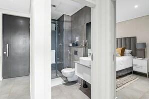 Une salle de bain moderne équipée d’une douche, de toilettes et d’un lavabo.