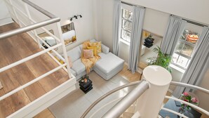 Un salon moderne avec un canapé gris, une petite table basse et un escalier.