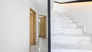 A modern interior with a marble staircase and wooden doors. - 7 Green Village (Grand-Baie)