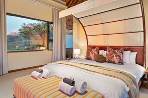 A hotel room with a large bed, a canopy, and a view of a mountainous landscape. - Villa Bezweni (Cape Town)