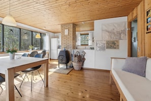 Ein modernes Interieur mit Holzboden, Essbereich, Küche und Wohnbereich.