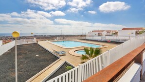 A rooftop pool with a view of the city, a white fence, and a clear sky. - Holiday Home 'Casa Vista Golf' with Sea View, Shared Pool & Wi-Fi (Castillo Caleta de Fuste)