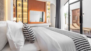 A modern bedroom with a large bed, a built-in wardrobe, a bedside table, and a large mirror. - Luxe Private Pool Villa Santisya 4, 4min-beach by Orivista (Mengwi)