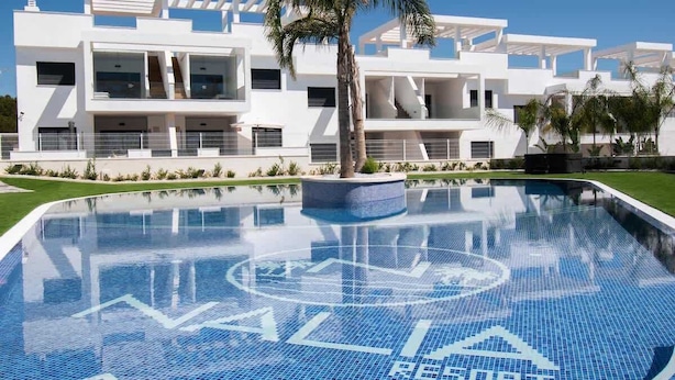 Un bâtiment moderne avec une piscine devant.