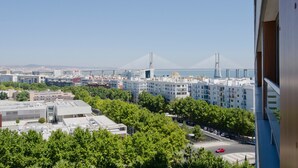 Stadtbild mit modernen Gebäuden, einer markanten Brücke und Blick auf das Meer.