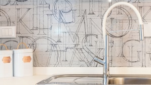 A kitchen with a modern faucet, a sink, and two white containers with handles. - Casinò Charme with Terrace by Wonderful Italy (Sanremo)