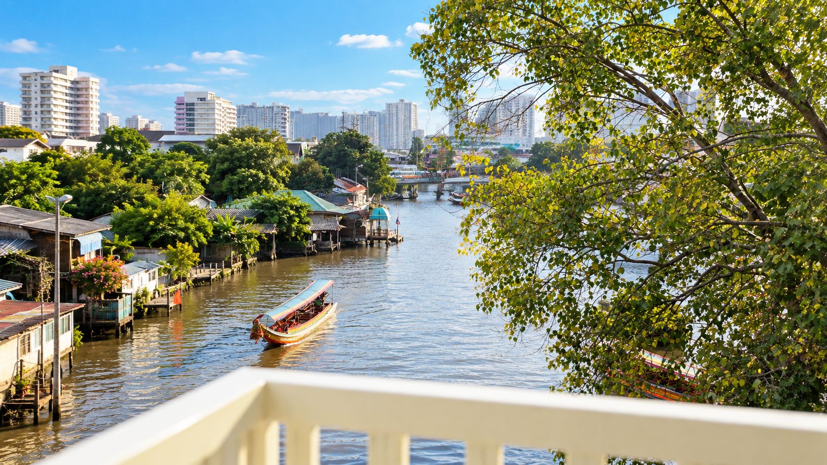 A river with traditional boats, a bridge, and modern buildings in the background.