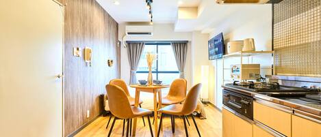 A modern kitchen with a stove, oven, and microwave. There is a dining area with a table and chairs.