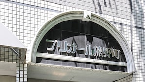 A building entrance with a tiled facade and a sign above the door.