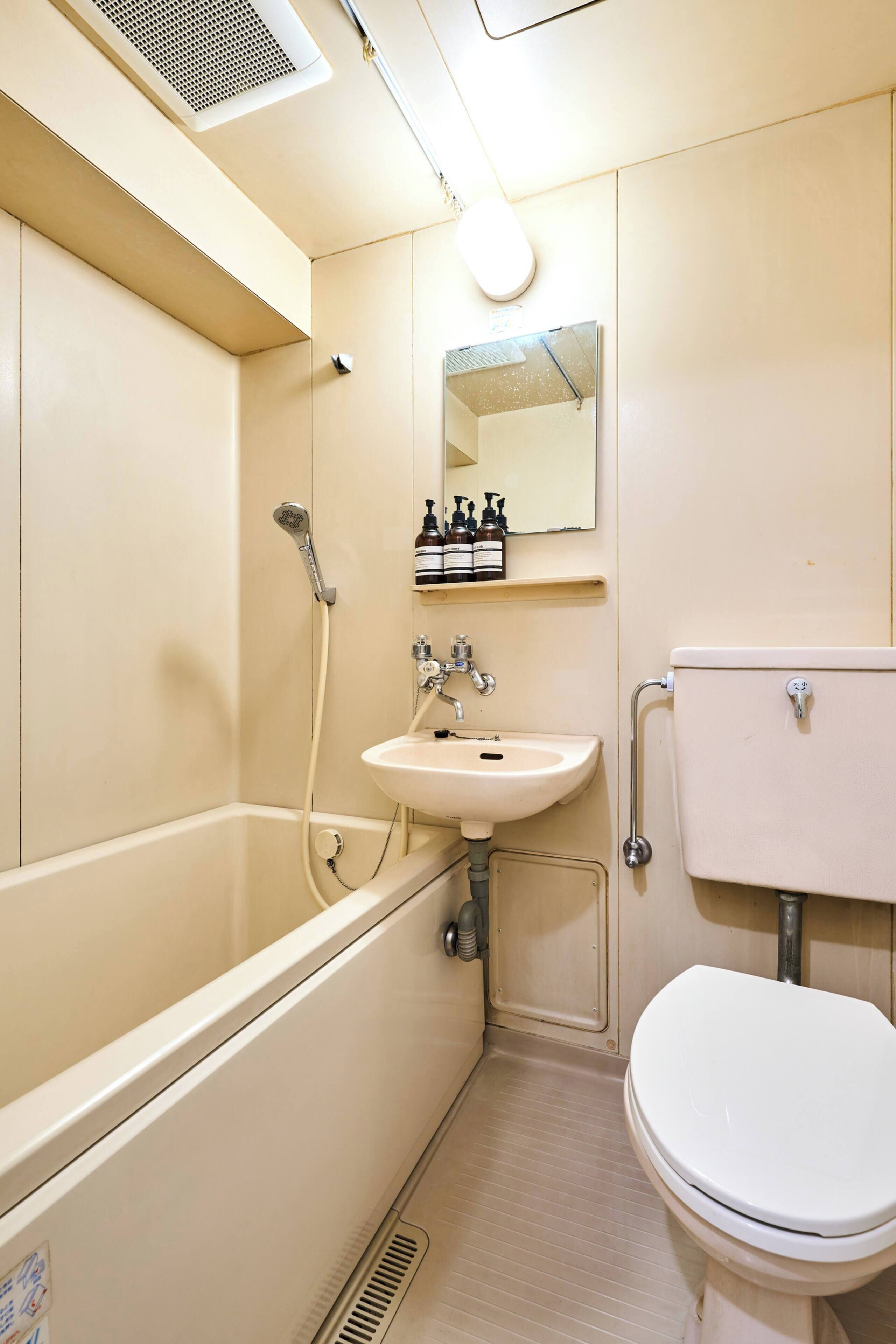 A small, compact bathroom with a bathtub, sink, and toilet.
