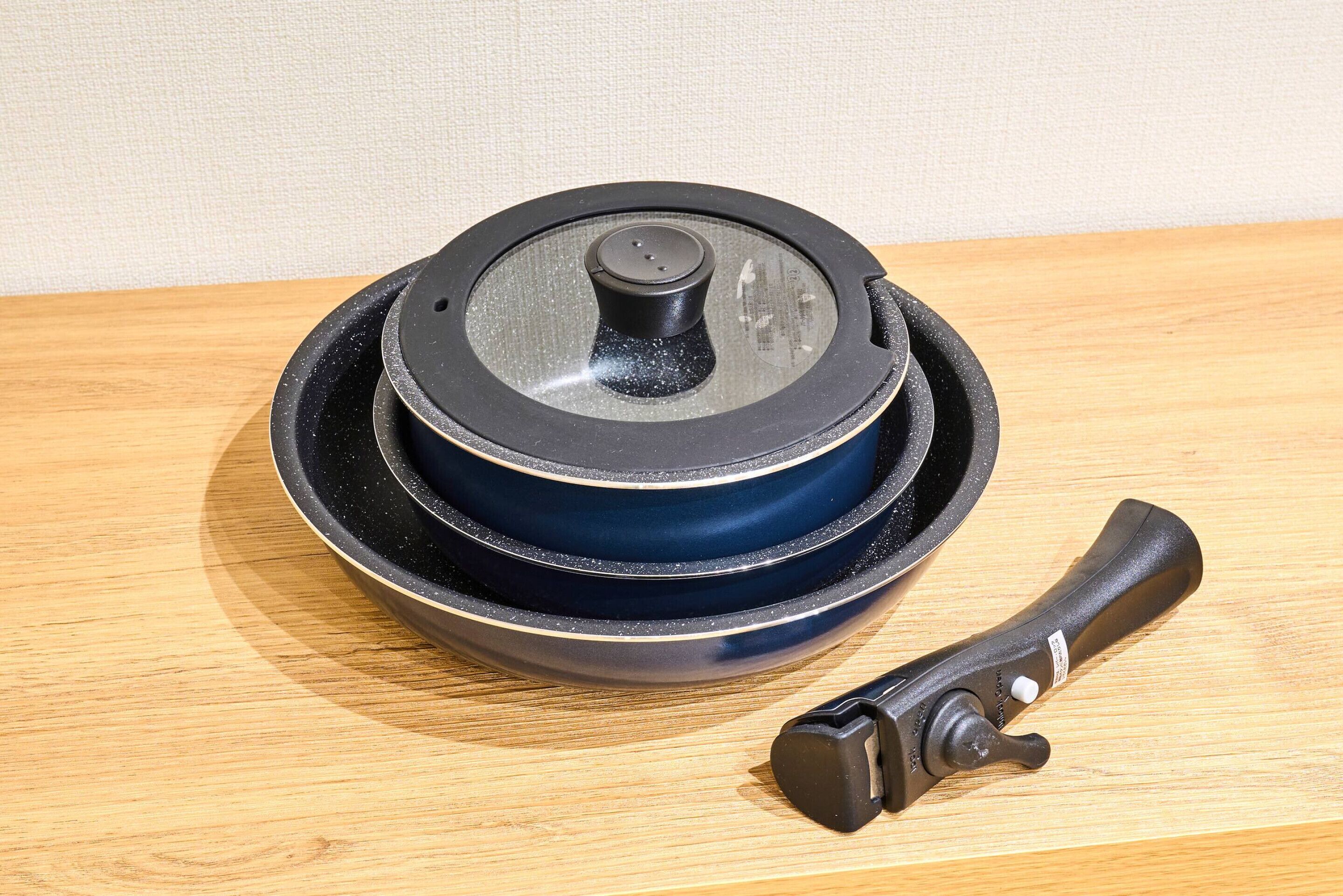 A black and blue portable heater with a control knob and a handle, placed on a wooden surface.