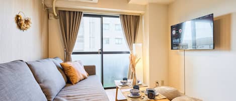 Departamento básico, para no fumadores, vista a la ciudad (802) | Área de sala de estar | Televisión de pantalla plana de 32 pulgadas con canales digitales