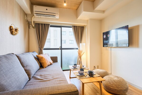 Departamento básico, para no fumadores, vista a la ciudad (802) | Área de sala de estar | Televisión de pantalla plana de 32 pulgadas con canales digitales 