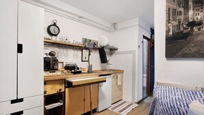 A compact kitchen with a wooden countertop, a sink, and a dishwasher. There is a clock on the wall and a framed picture above the counter. - Guest House 'Ca Du Grifun' with Wi-Fi and Air Conditioning (Vernazza)