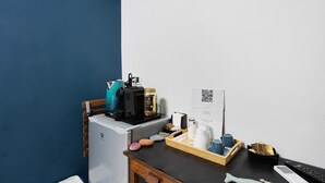 A compact room with a kitchenette, a small refrigerator, a coffee machine, a tray with cups and a remote control, and a QR code on the wall. - Guest House 'Ca Du Grifun 2' with Wi-Fi and Air Conditioning (Vernazza)