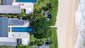 An aerial view of a beachfront property with multiple swimming pools, a beach, and lush greenery. - Villa Cielo (Takua Thung)