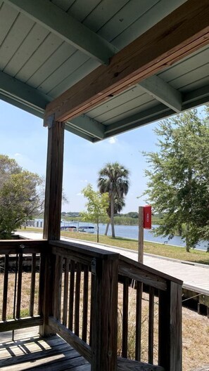 Una terraza de madera con vistas a un lago y árboles.