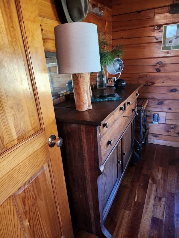 Un interior de madera con un armario, un ventilador y una puerta.