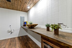 Una cocina con encimeras y techo de madera, y paredes blancas.